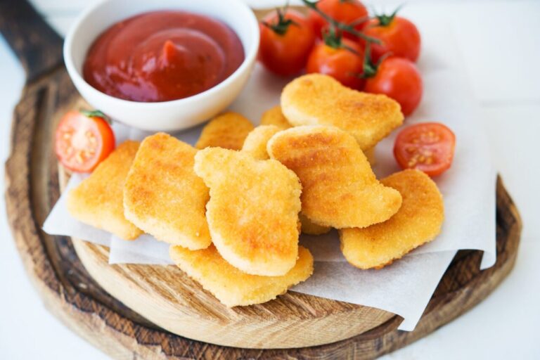 Assiette de nuggets de poulet maison dorés et croustillants, servis avec une sauce dip.