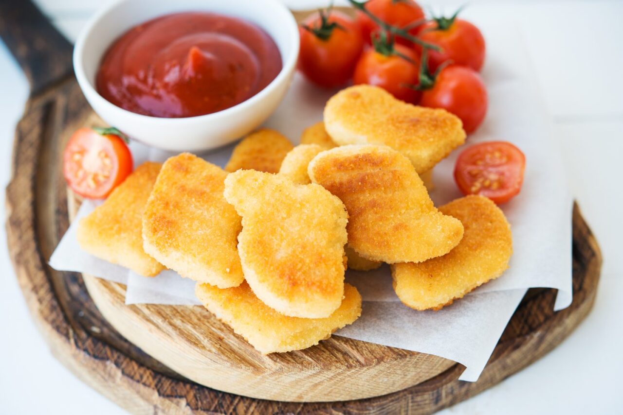 Assiette de nuggets de poulet maison dorés et croustillants, servis avec une sauce dip.